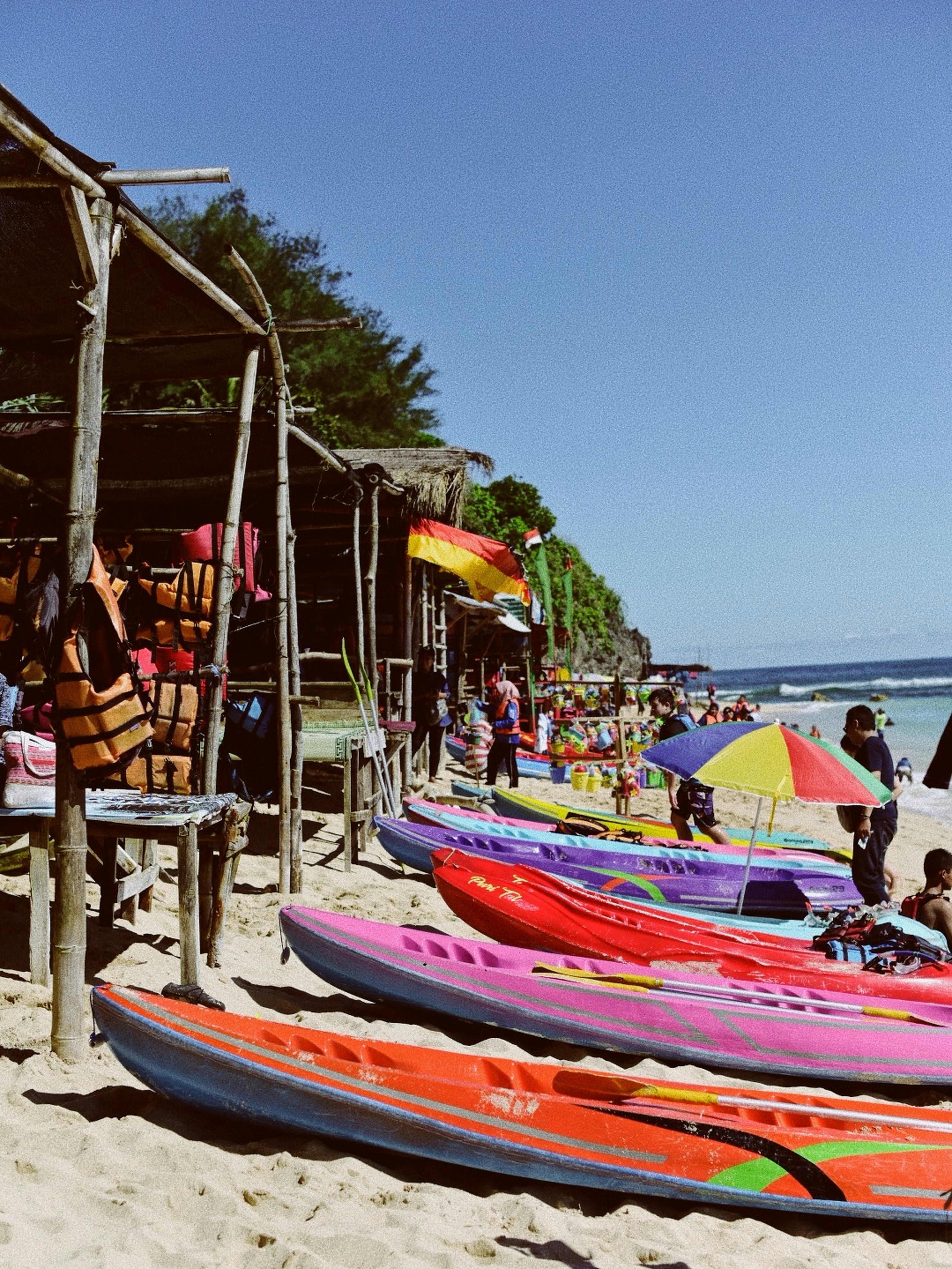 red and blue boat on beach during daytime