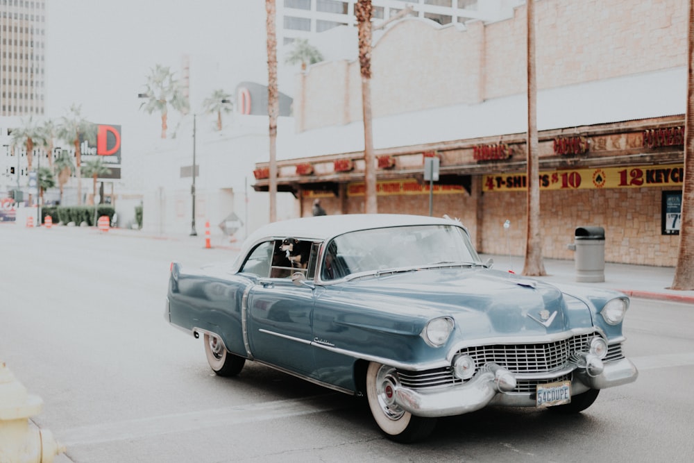 blue classic car on road during daytime