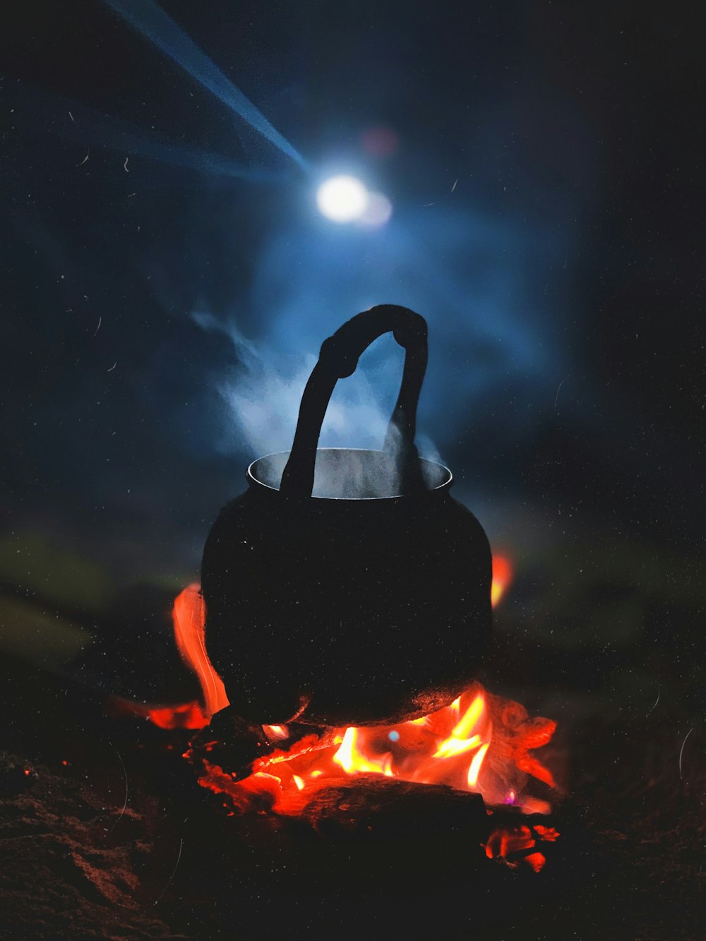 person in black hoodie standing on fire during nighttime