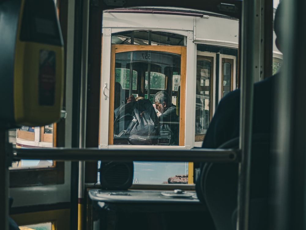 man in black jacket sitting on bus seat