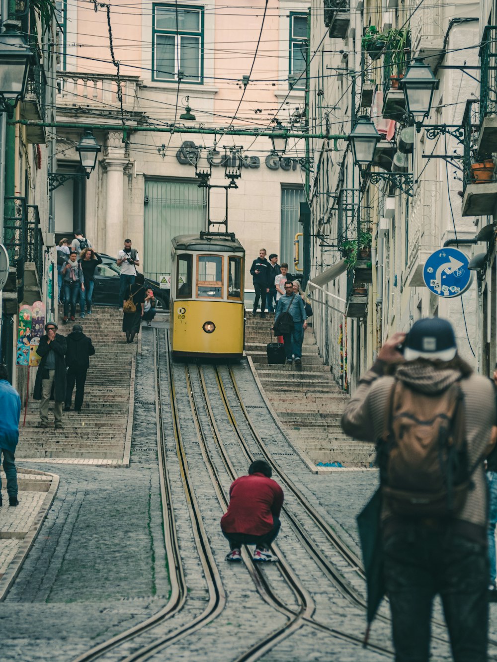 people walking on the street near yellow tram during daytime