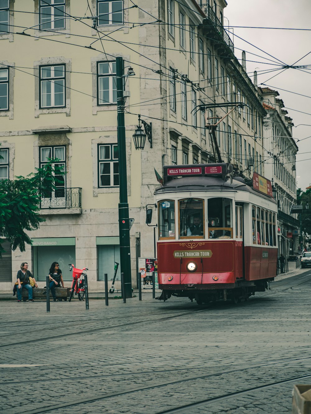 red tram on road near building during daytime