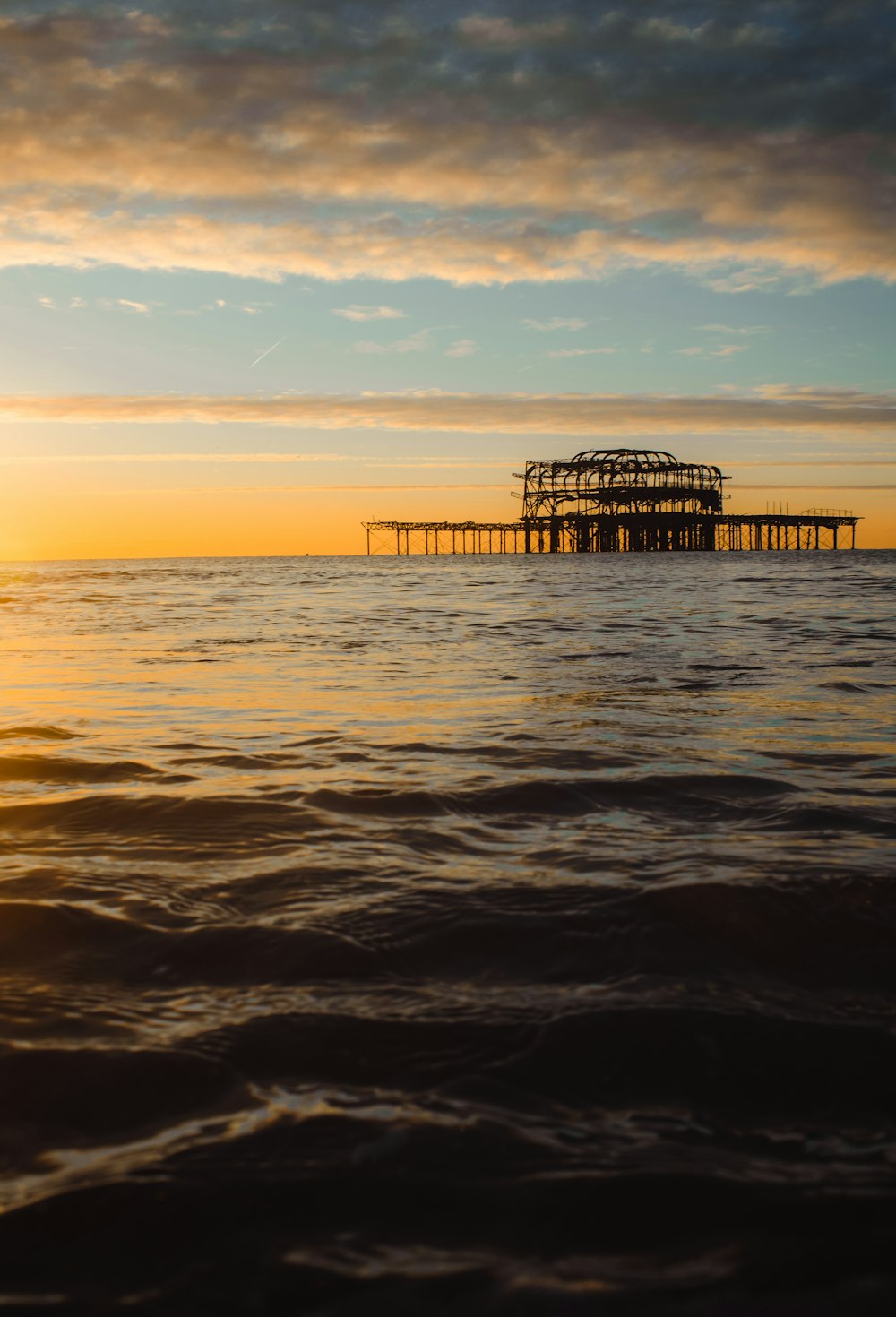 brown wooden dock on sea during sunset