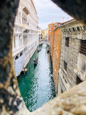 body of water between concrete buildings during daytime