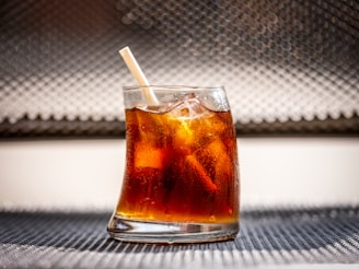 clear drinking glass with brown liquid