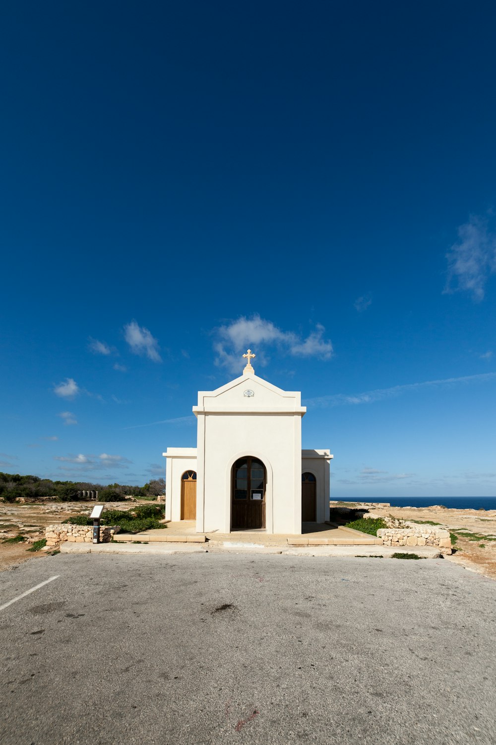 bâtiment en béton blanc près de la mer sous le ciel bleu pendant la journée