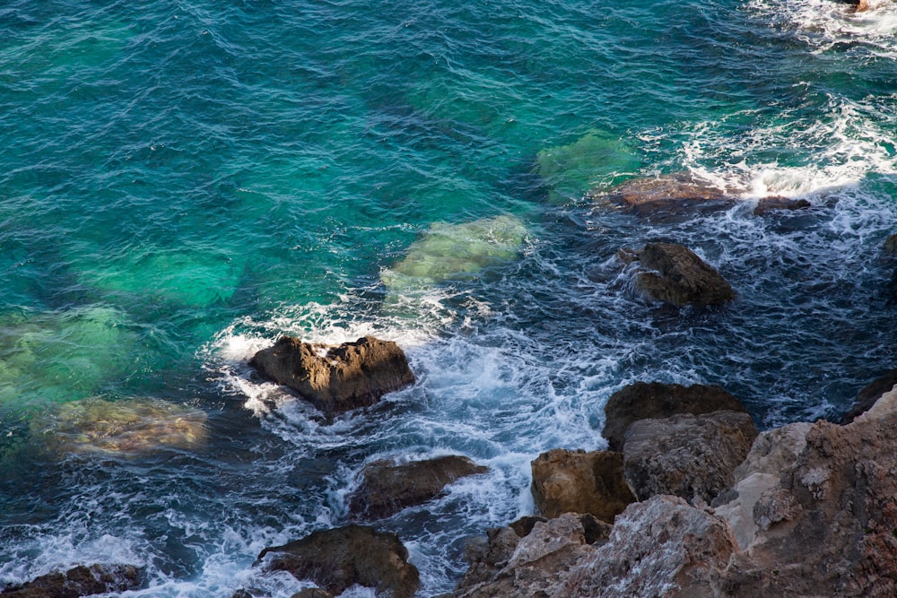 brown rock formation on body of water during daytime