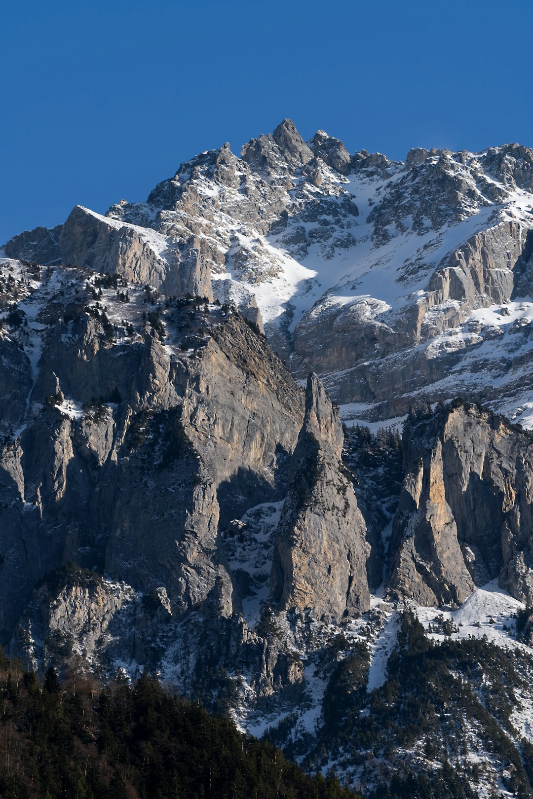 brown rocky mountain covered with snow during daytime