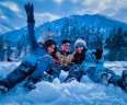 3 women lying on snow covered ground during daytime