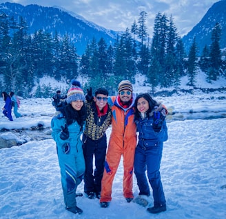 2 women and man standing on snow covered ground during daytime