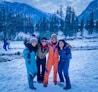 2 women and man standing on snow covered ground during daytime