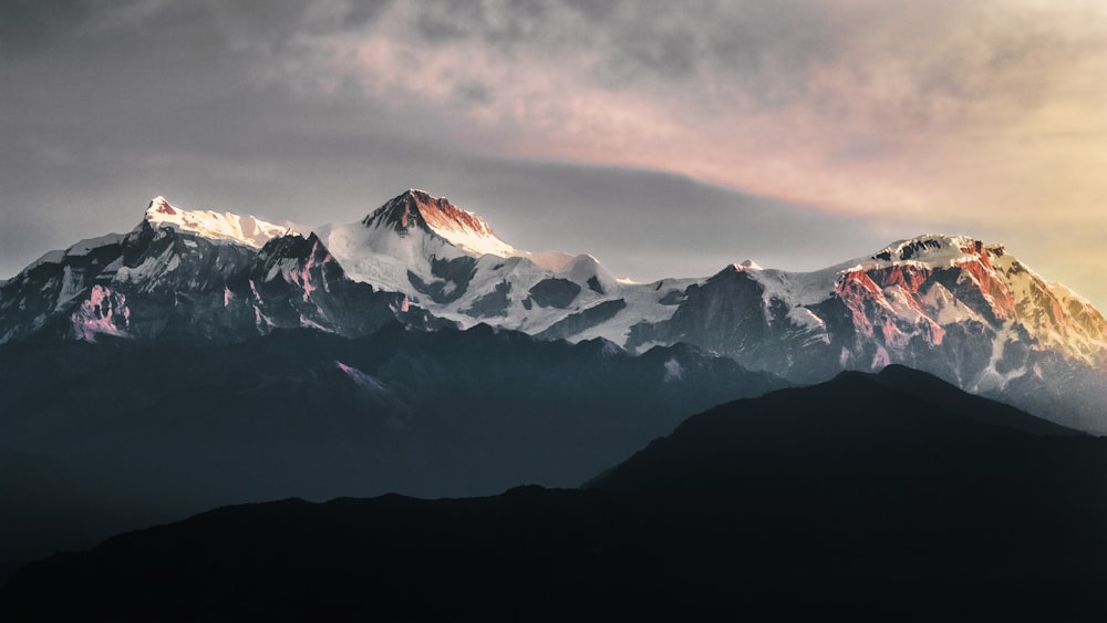 a view of a mountain range with clouds in the background