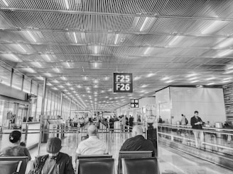 grayscale photo of people sitting on chair