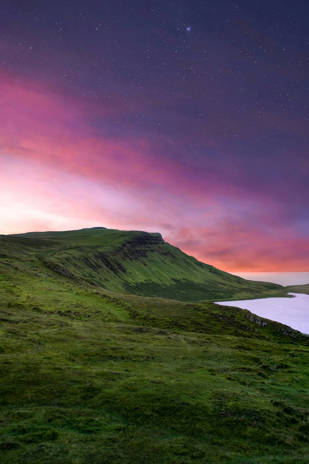 紫色の空の下の緑の山