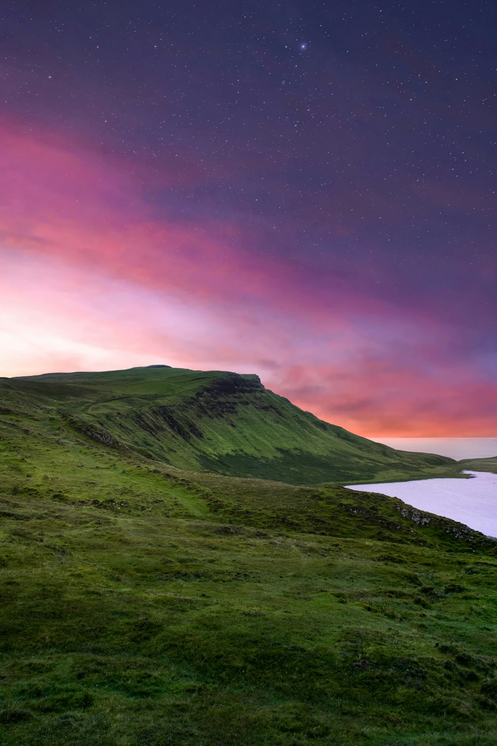 Montaña verde bajo el cielo púrpura