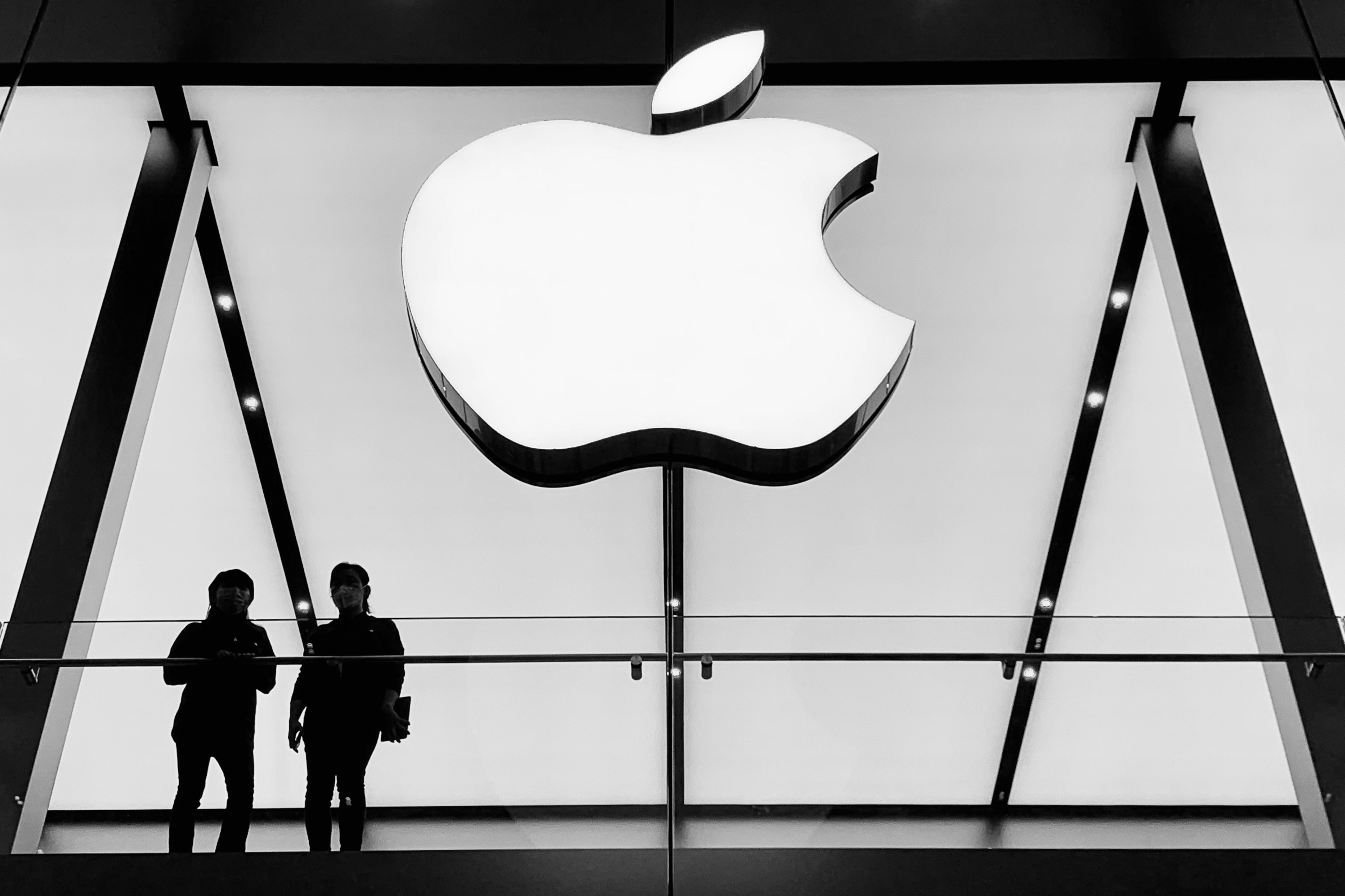Jan. 2020, Chengdu, China - Two staffs was looking down the crowd in Taikoo Li shopping center through the window of the Apple Store. Although people’s enthusiasm for shopping seemed not to have been deterred by the Corona virus from Wuhan because of the coming lunar New Year, many of them was wearing surgical masks. So did the Apple staffs.