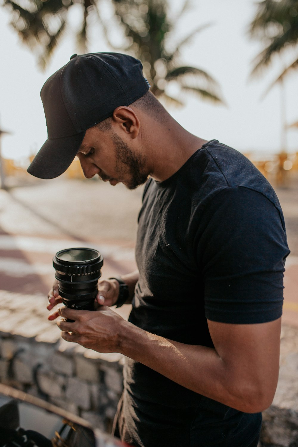 man in black crew neck t-shirt holding black dslr camera lens