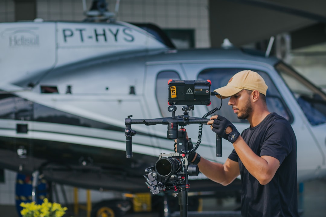 man in blue crew neck t-shirt holding black video camera