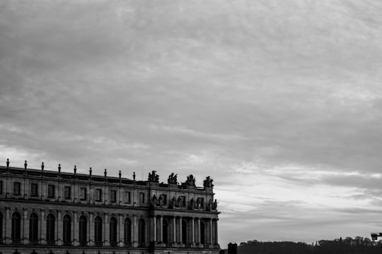 grayscale photo of concrete building in Gardens of Versailles France