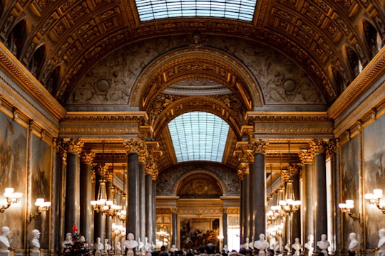 people walking inside building during daytime in Palace of Versailles France