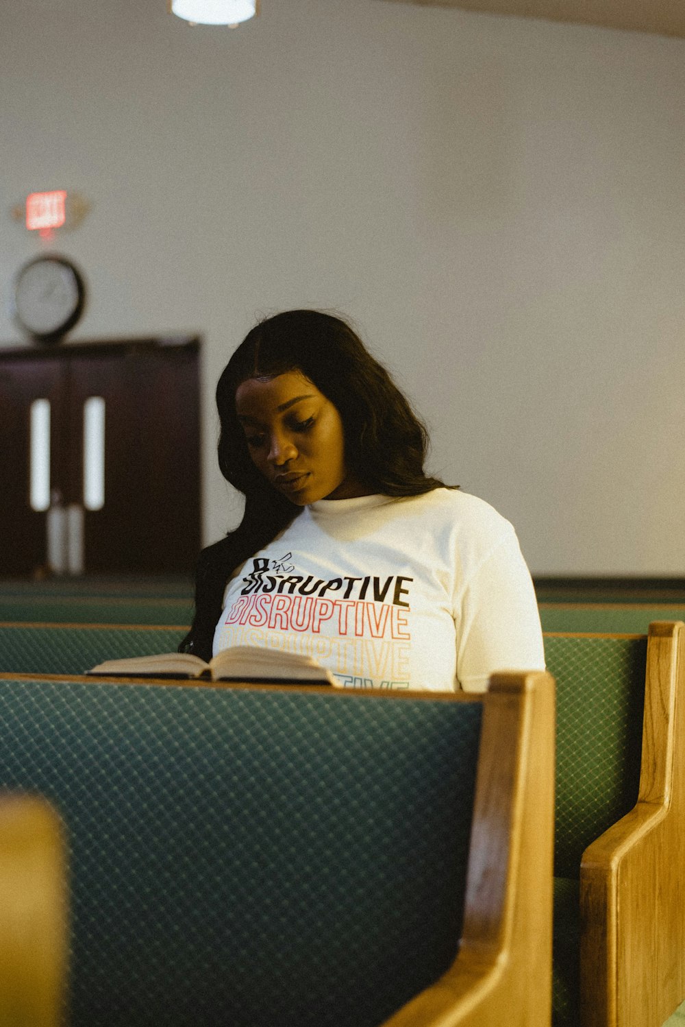 woman in white and red crew neck t-shirt sitting on chair