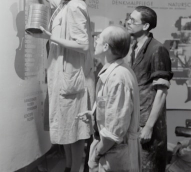 grayscale photo of man and woman standing beside boy