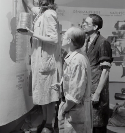 grayscale photo of man and woman standing beside boy