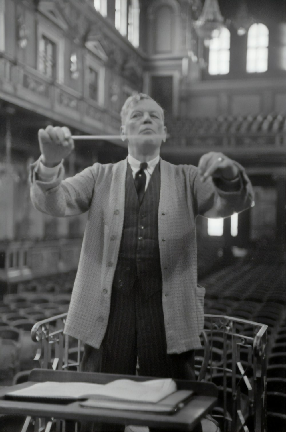 man in black and white suit holding a microphone