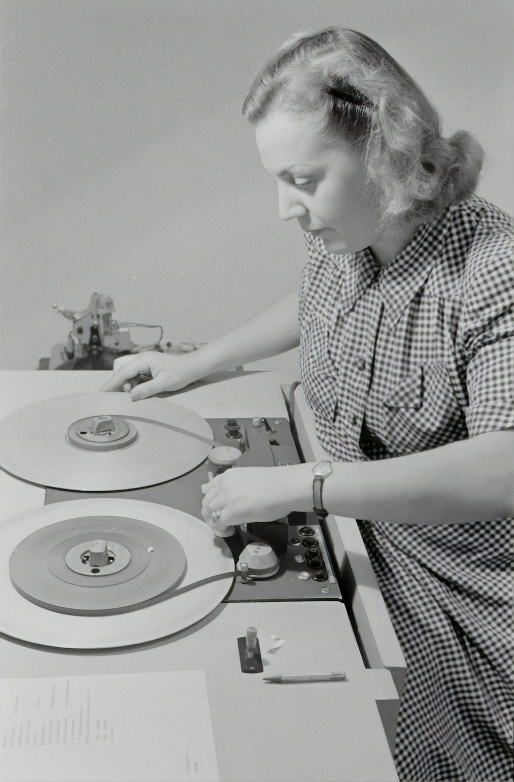 Hombre en camisa abotonada a cuadros en blanco y negro tocando DJ tocadiscos