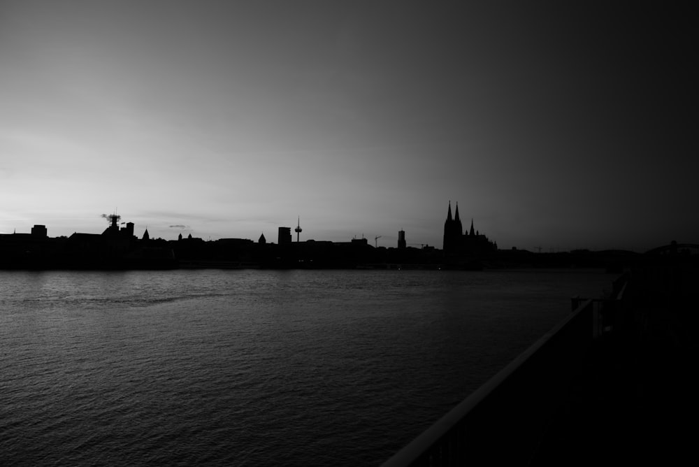 grayscale photo of city buildings near body of water