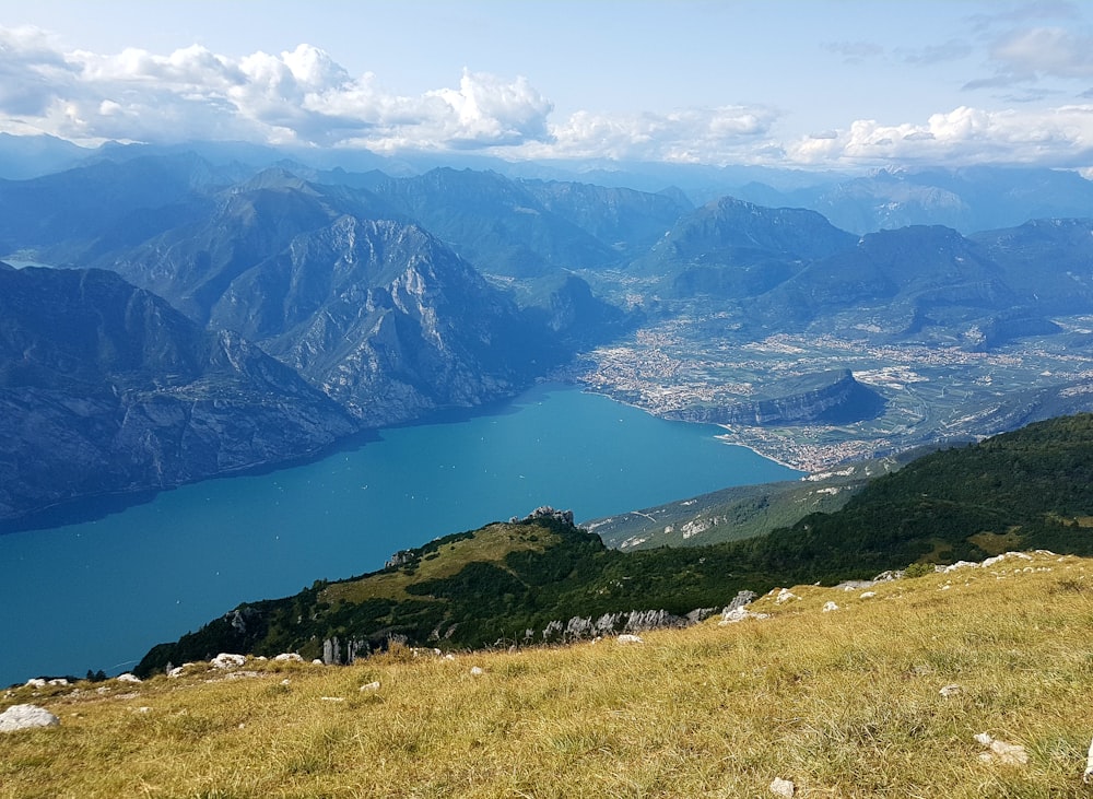 Grünes Grasfeld in der Nähe von See und Bergen während des Tages