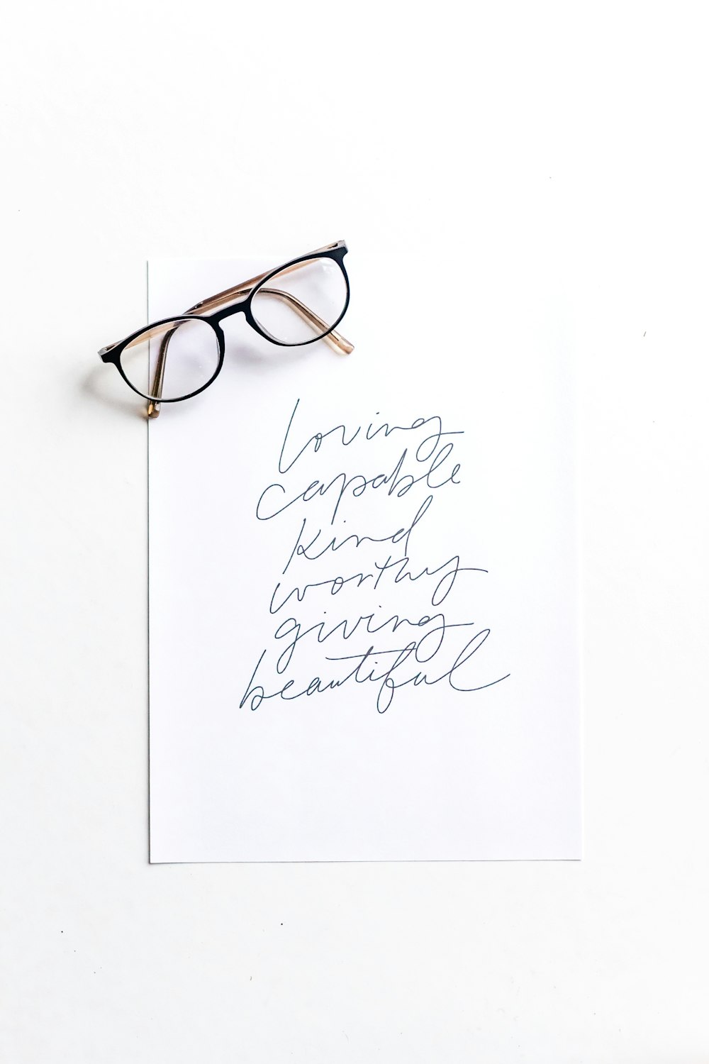 brown framed eyeglasses on white printer paper