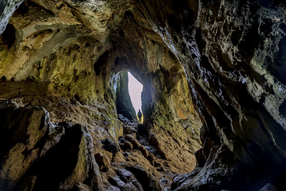 grotte brune et noire avec de l’eau bleue