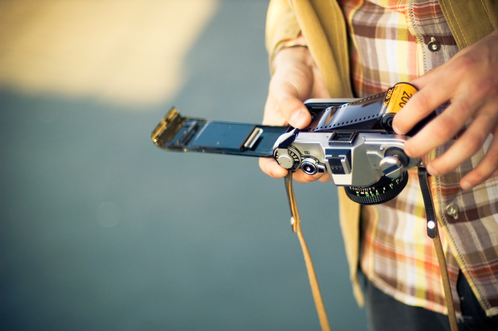 person holding black and silver dslr camera