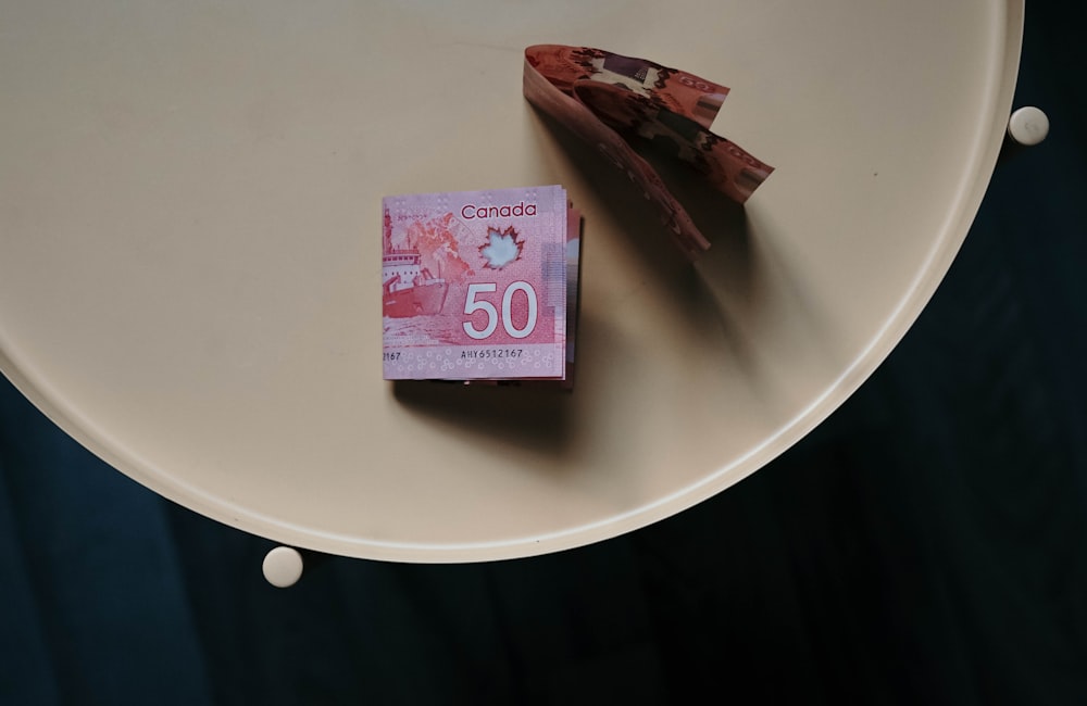 Banconota da 100 su tavolo rotondo bianco