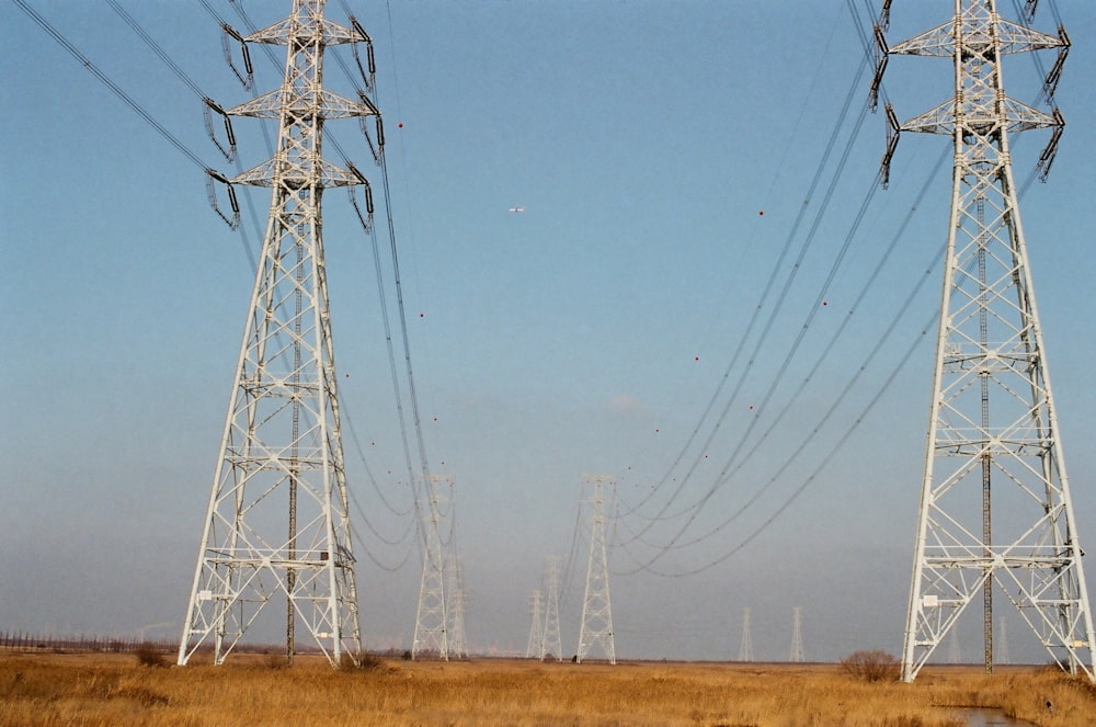 gray steel electric towers under blue sky during daytime