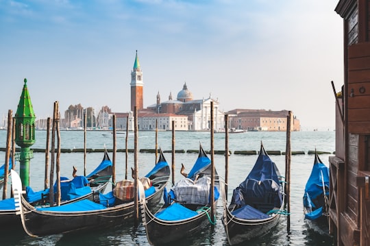blue and brown boat on body of water near brown concrete building during daytime in Church of San Giorgio Maggiore Italy