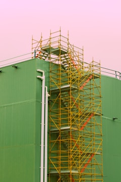white metal ladder beside green wall