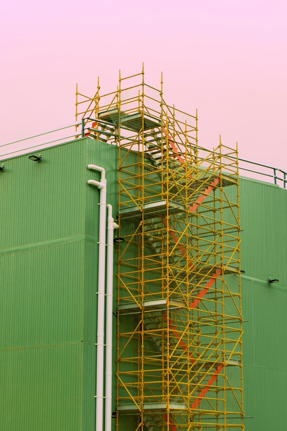 white metal ladder beside green wall