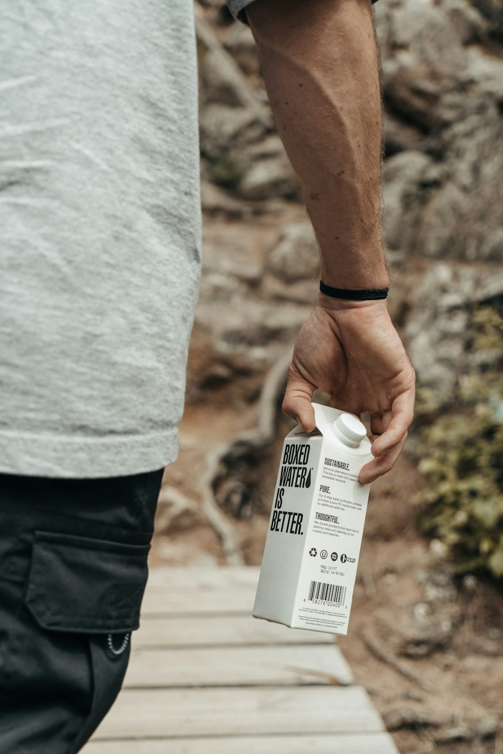 person holding white and black labeled soft tube