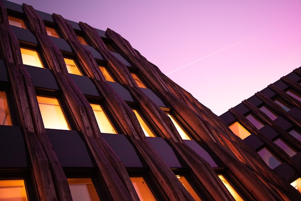 Exterior view of a modern Toronto condo with large windows and wooden accents at sunset.