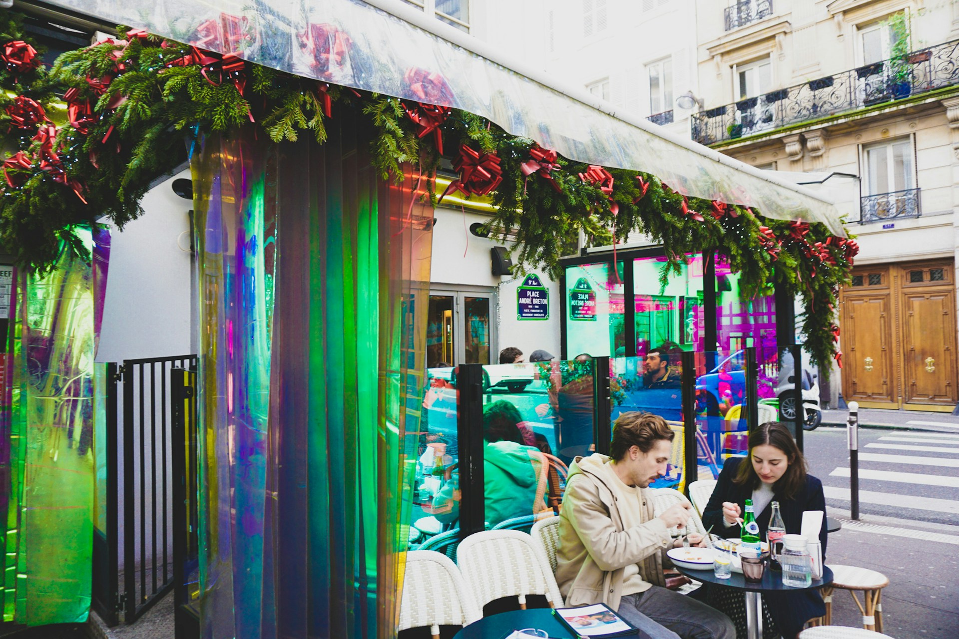 Decorated party setting at Porche Gurugram Cafe with festive lighting and happy guests sharing laughter over drinks and snacks.
