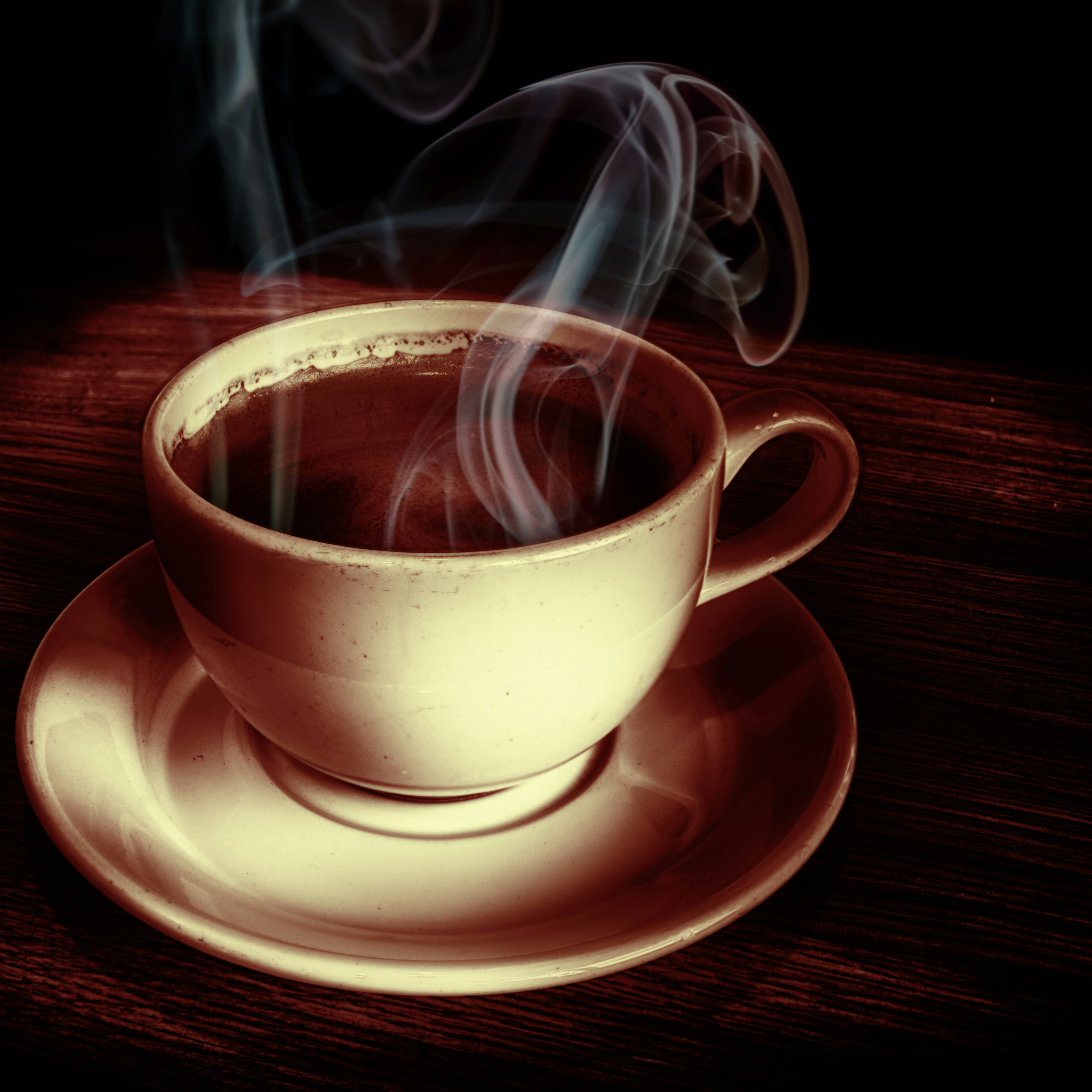 Coffee product photography in dark moody setting, steam rising from cup, low-key chiaroscuro lighting, dark wooden surface