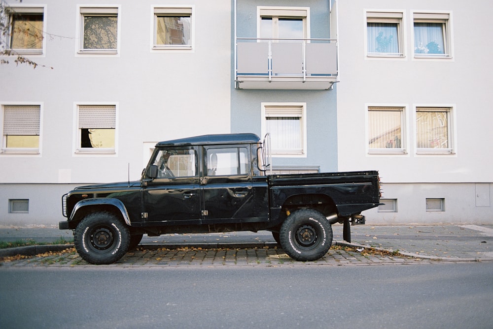 black and white jeep wrangler parked beside white building