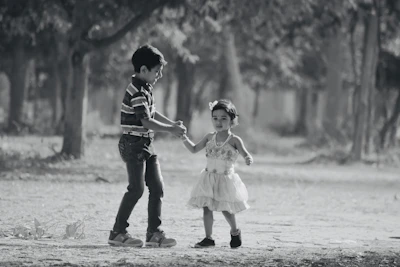 Smiling boy and girl walking hand in hand wearing trendy shoes