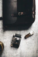 A moody flat lay featuring open perfume boxes, scent notes, and a vintage fragrance vial on a charcoal surface.