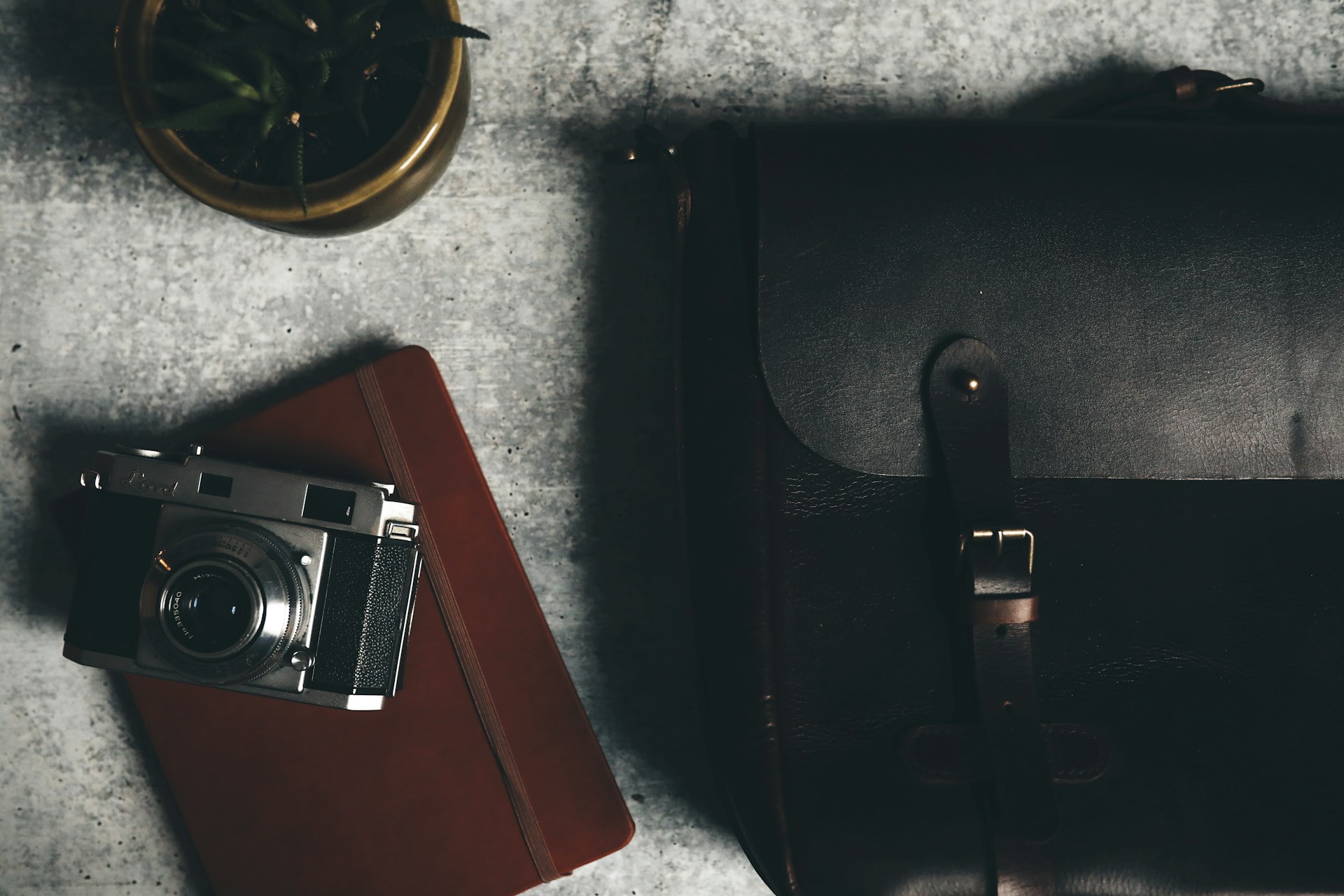 black and silver point and shoot camera on black leather case