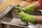 A professional plumber repairing a sink with tools in a bright kitchen.