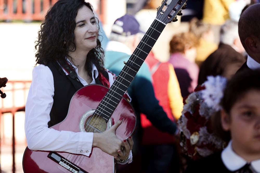 woman in white shirt playing acoustic guitar