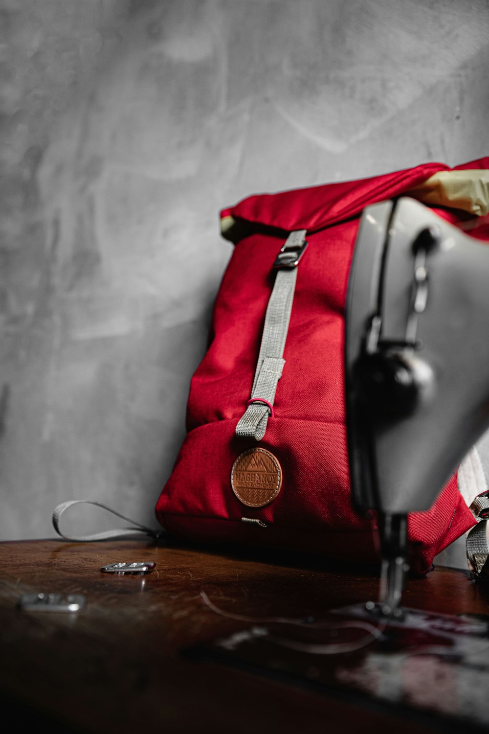 black and red leather handbag on brown wooden table